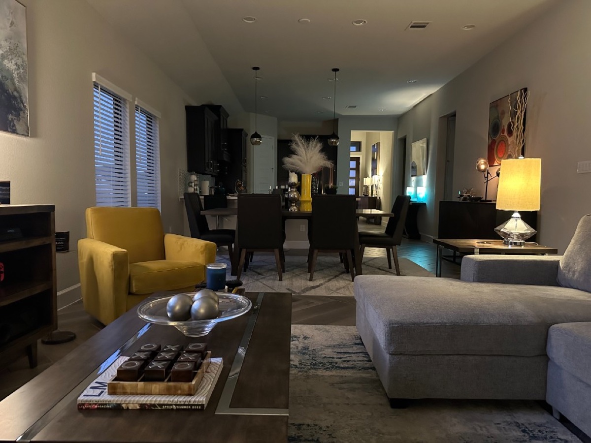 Open living and dining room with layered lighting and neutral palette